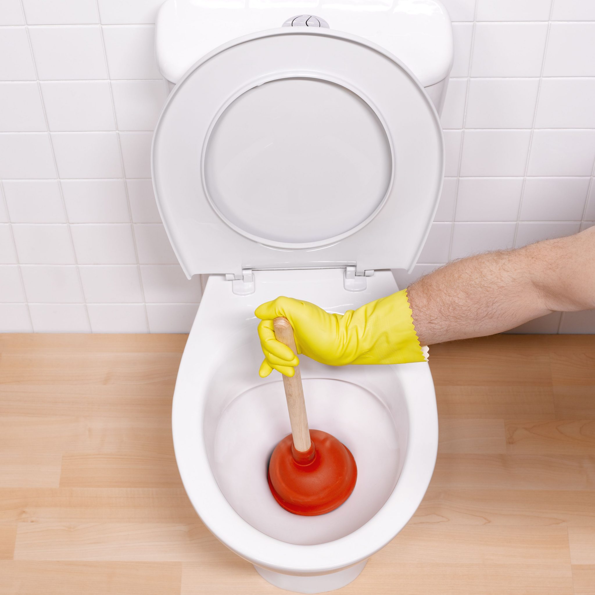 man-sticking-toilet-plunger-in-toilet-bowl-82370430-581caac55f9b581c0b263c82